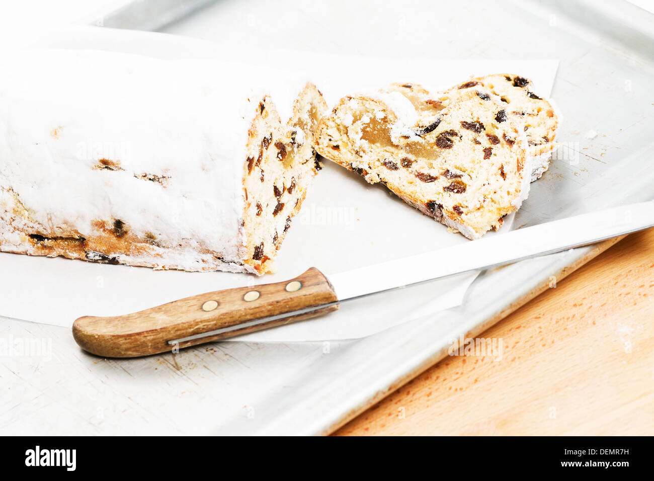 christmas stollen cake with a knife on a silver metal baking tray Stock Photo