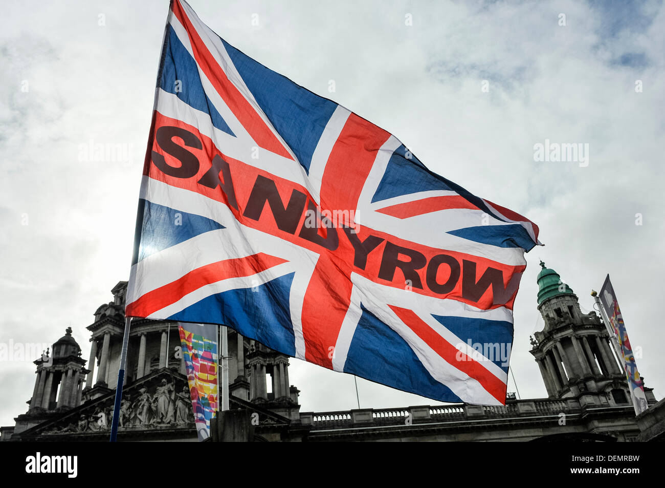Belfast, Northern Ireland, 21st September 2013 - Union Flag with "Sandy Row" across the middle is waved in front of Belfast City Hall Credit:  Stephen Barnes/Alamy Live News Stock Photo