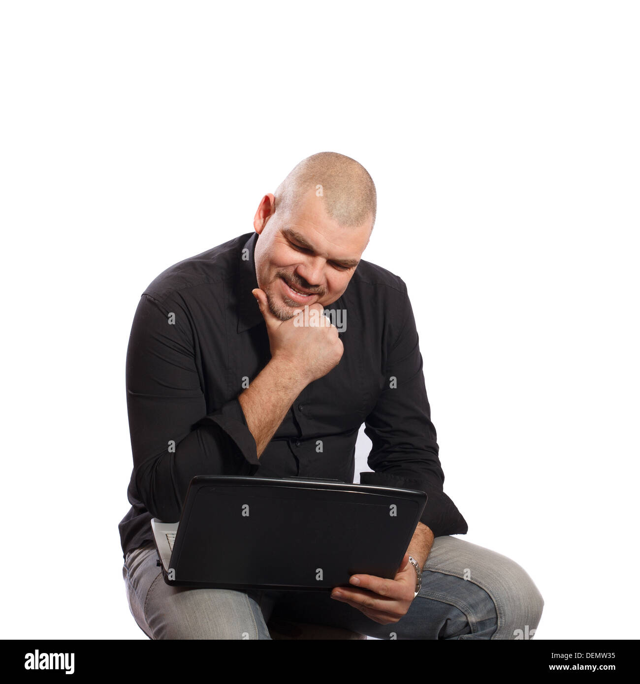 Thoughtful man sitting and looking at her computer on white background Stock Photo