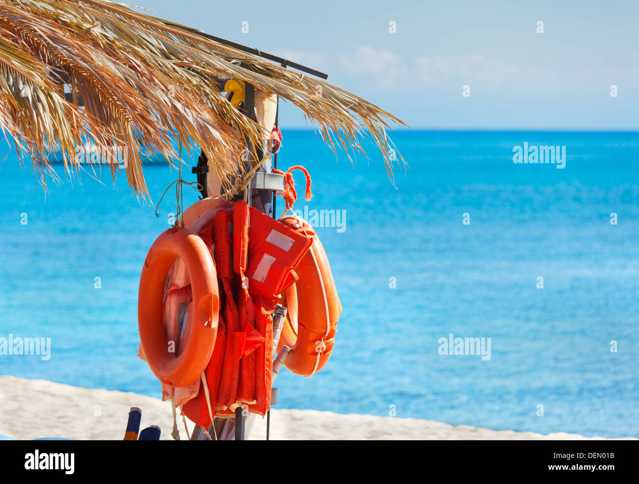 Life-buoys on the beach under palm leaves Stock Photo