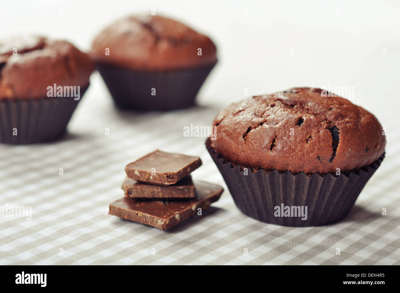 Chocolate Muffins on checkered tablecloth closeup Stock Photo
