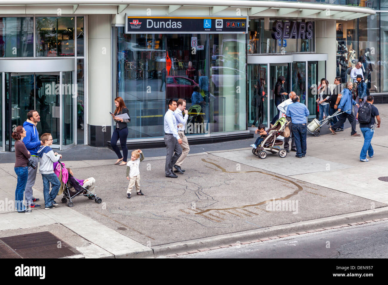 Family looking at map of Toronto in the sidewalk outside the entrance to the Dundas subway station - Yonge, Street, Toronto Stock Photo
