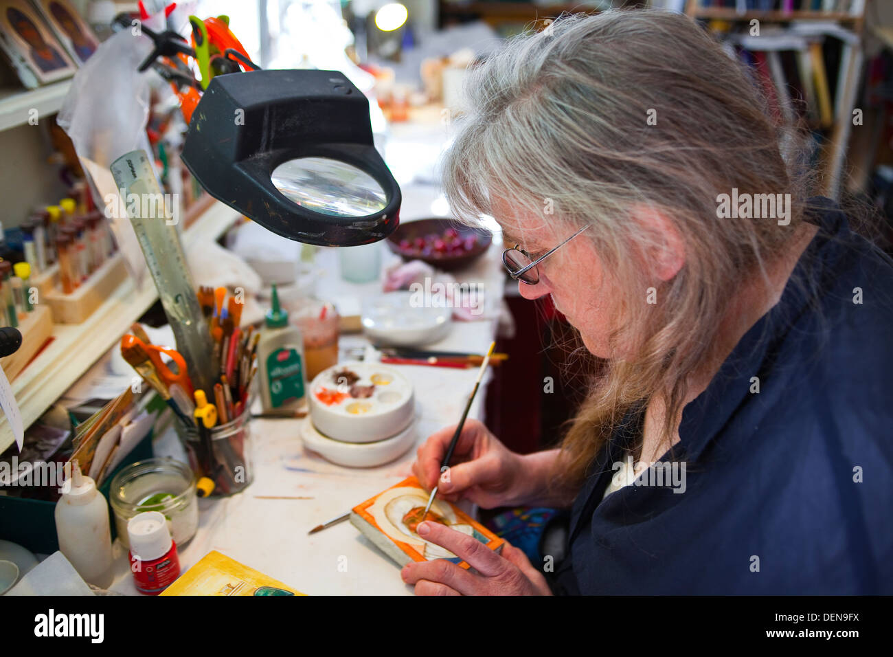 Anne-Marie Bonhomme painting an icon in her workshop next to the basilica in Vezelay. Stock Photo