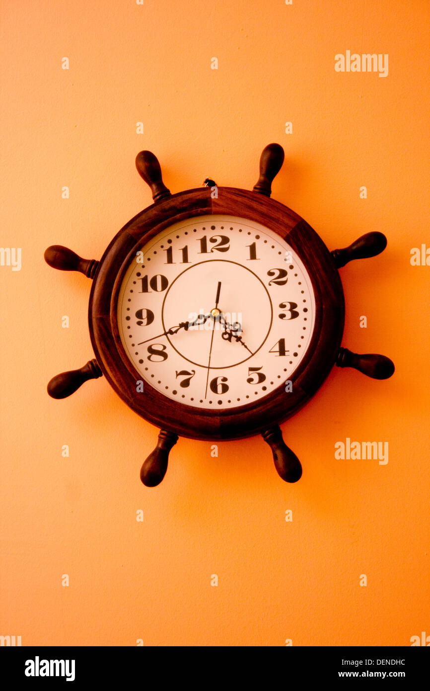 Brown Clock Hanging on Orange Wall Stock Photo