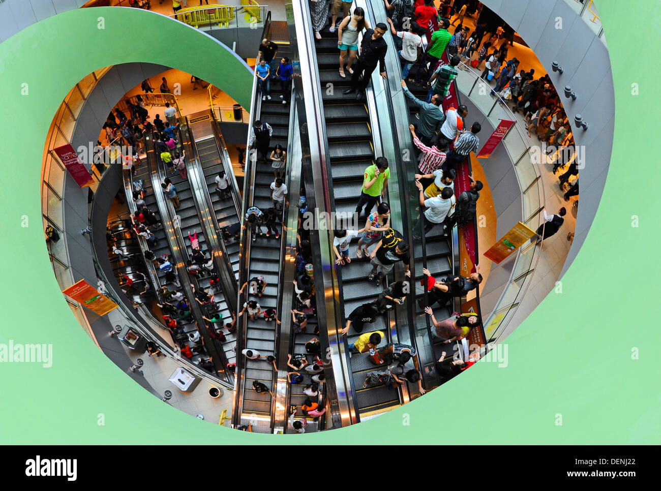 Shoppers and tourists using the escalators in the shopping center on Sentosa island in Singapore. Stock Photo