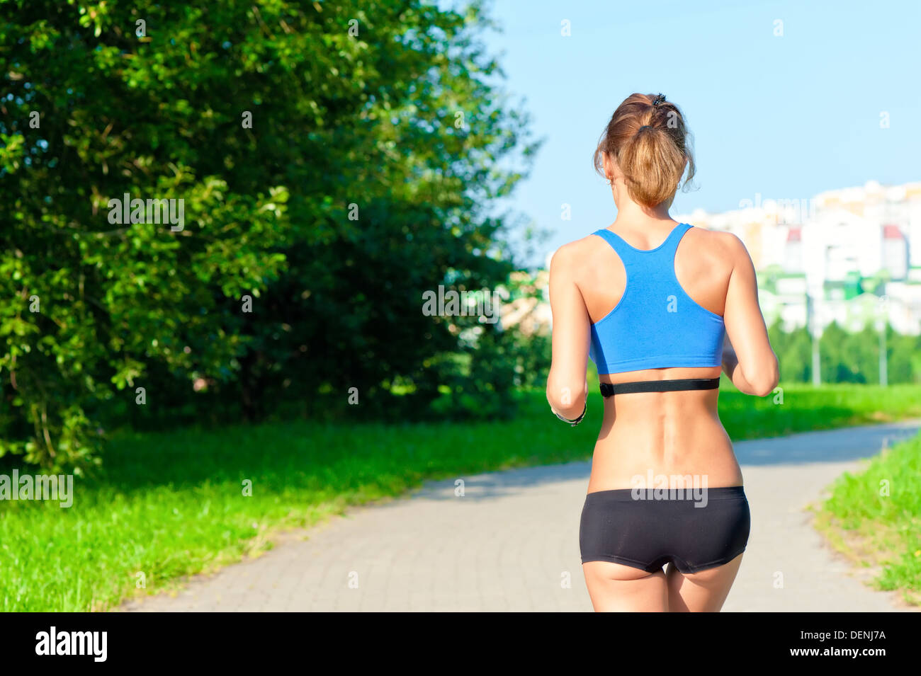 Female runner on beach with sports bra and shorts. Midsection closeup of  body of a woman athlete running with speed fast training cardio wearing  neon yellow activewear outfit. Active lifestyle. Photos