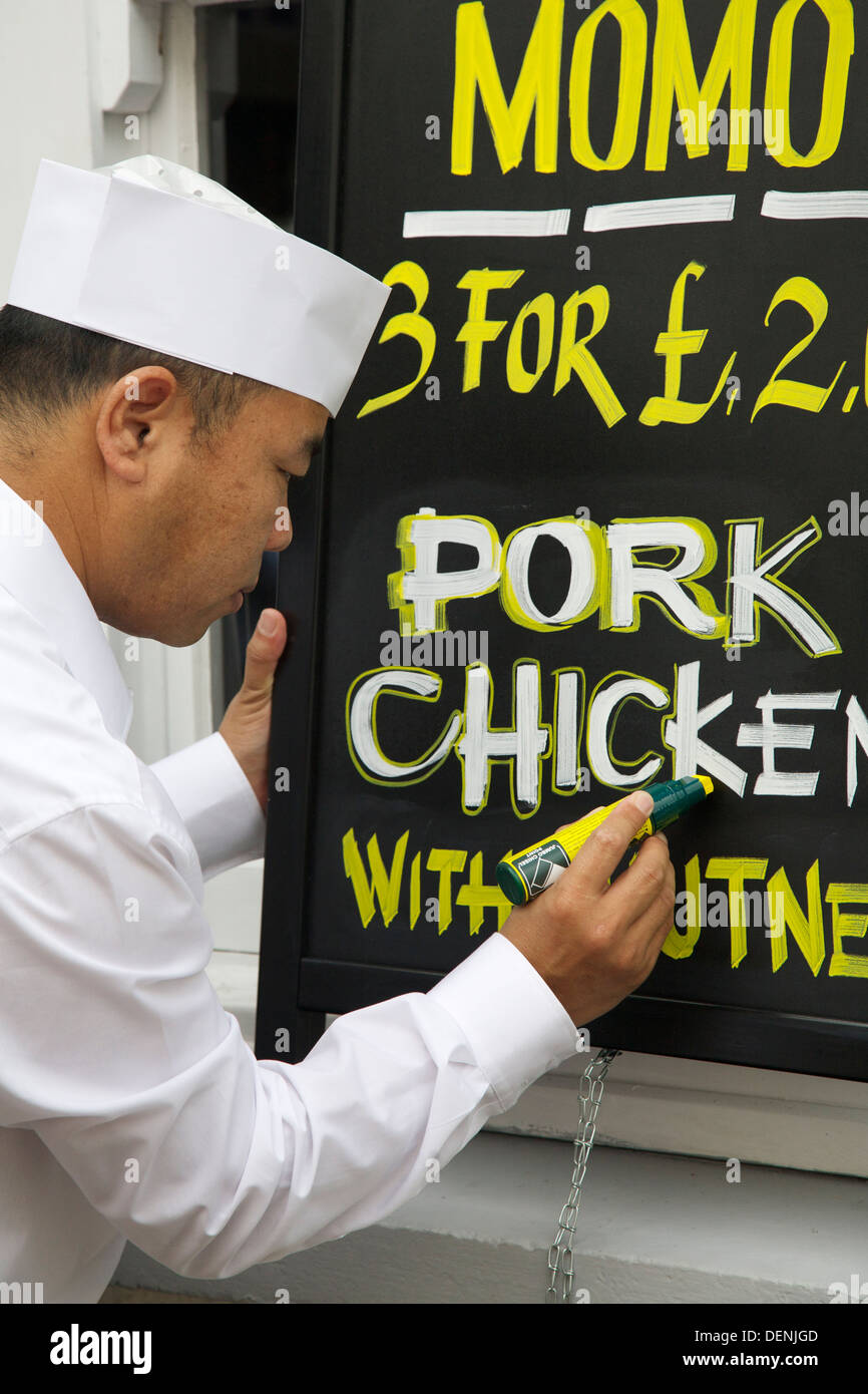 A former Gurkha soldier chef writes a sign at the Himalayan and Nepalese Restaurant, Abergavenny Stock Photo