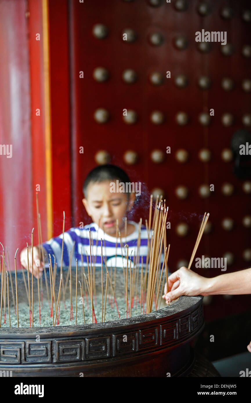 Burning incense placed in a large metal container at the Buddha Tooth