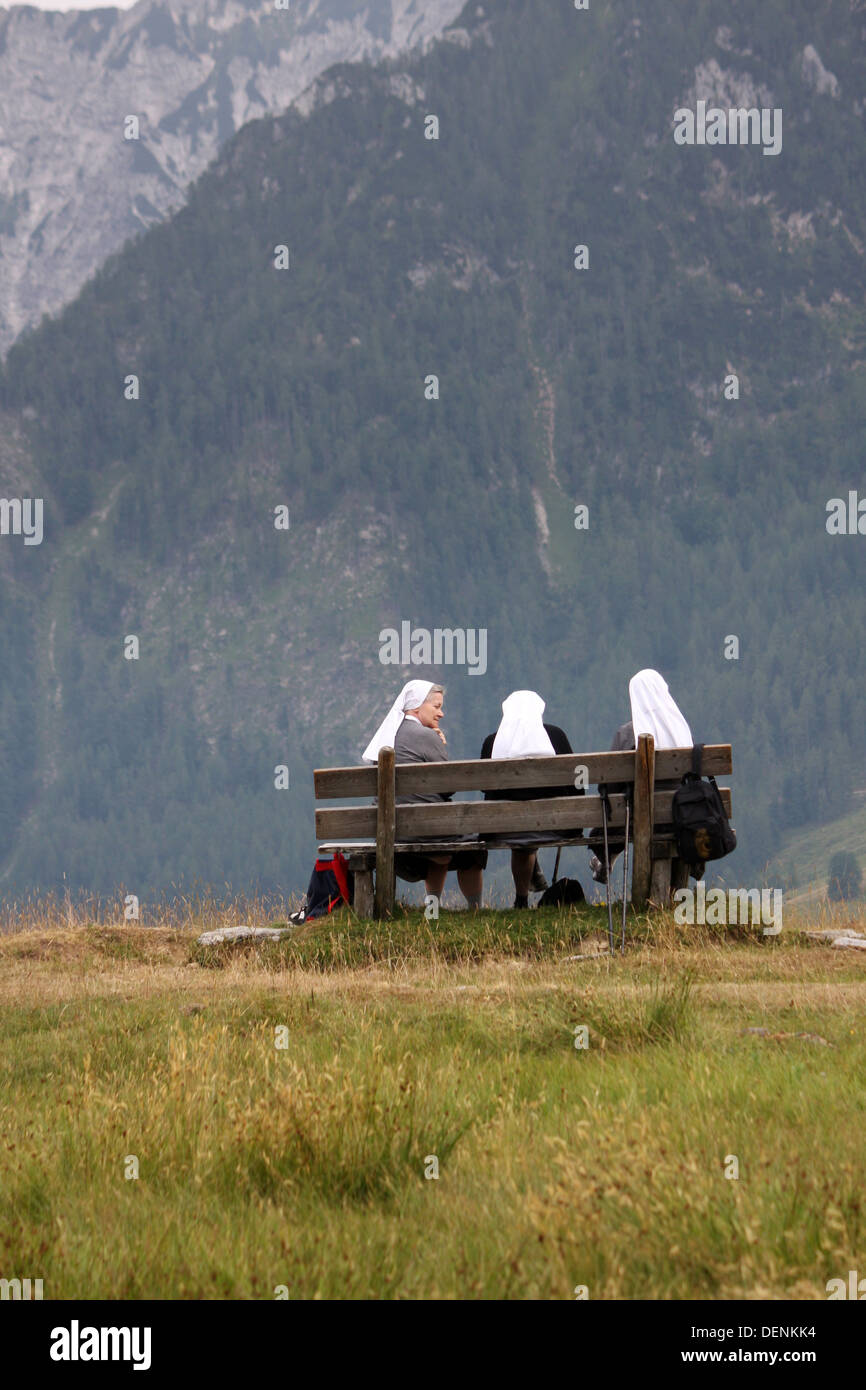 Nuns on bench in alps Stock Photo
