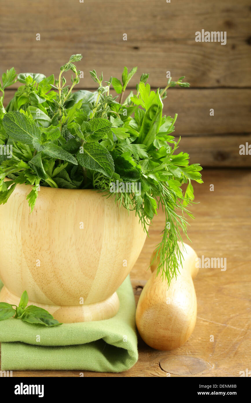 various herbs (basil, thyme, parsley, mint and dill) on wooden
