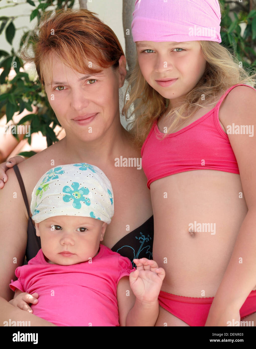 Outdoor summer family portrait of Young Caucasian mother and two her children Stock Photo