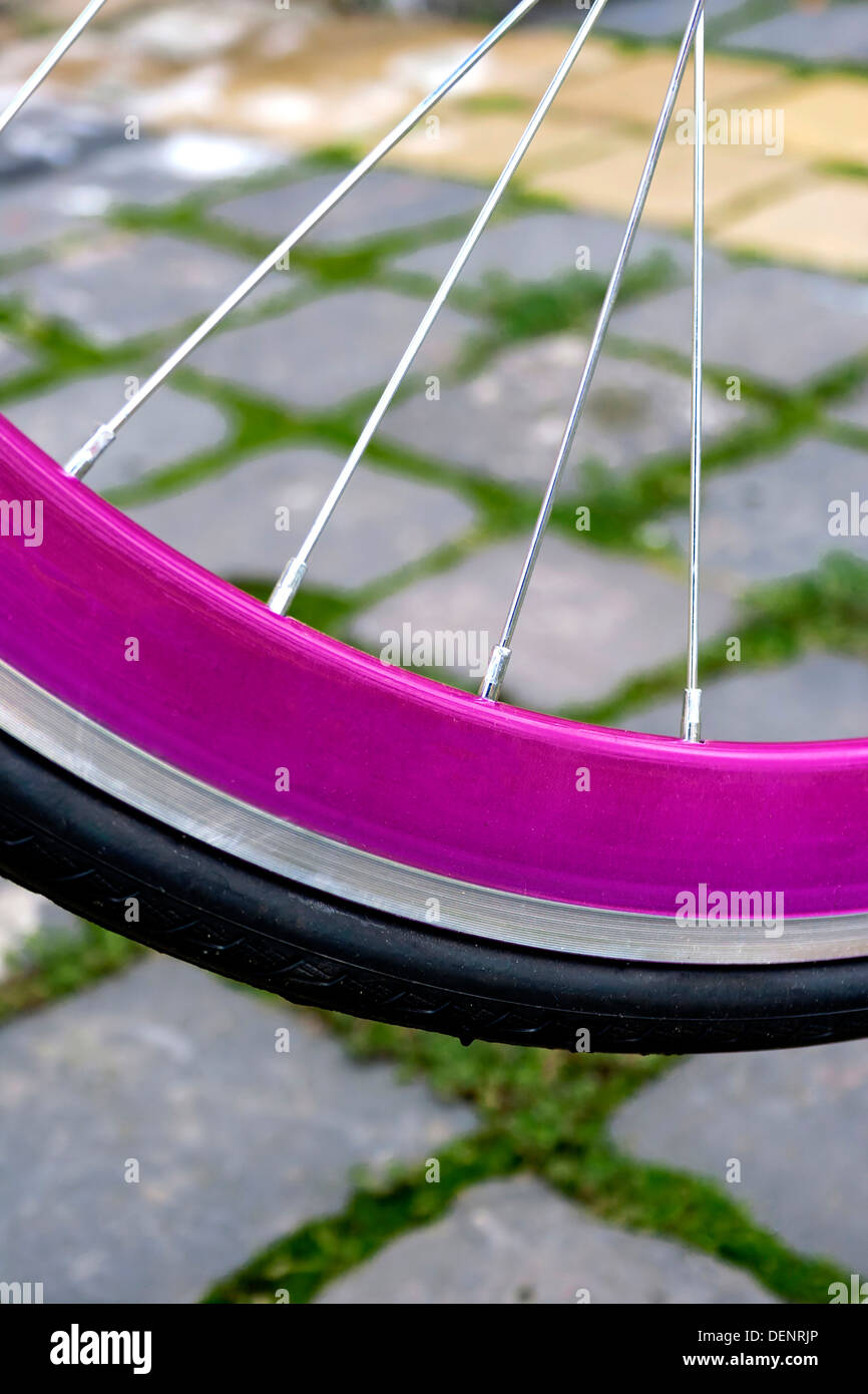 Detail of a bicycle wheel rubber, with pink rim, on a paving Stock ...
