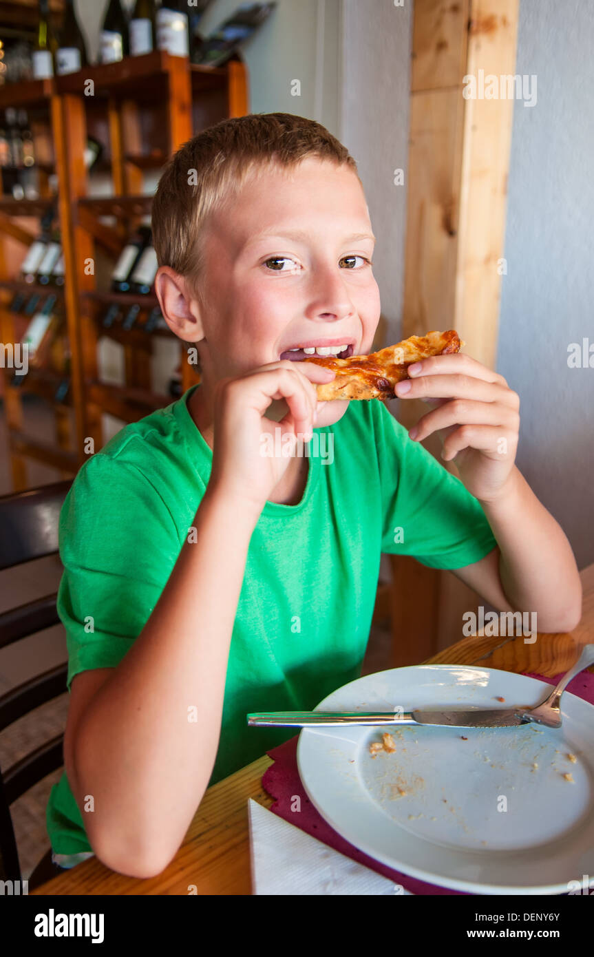 Young boy eating pizza at restaurant Stock Photo Alamy