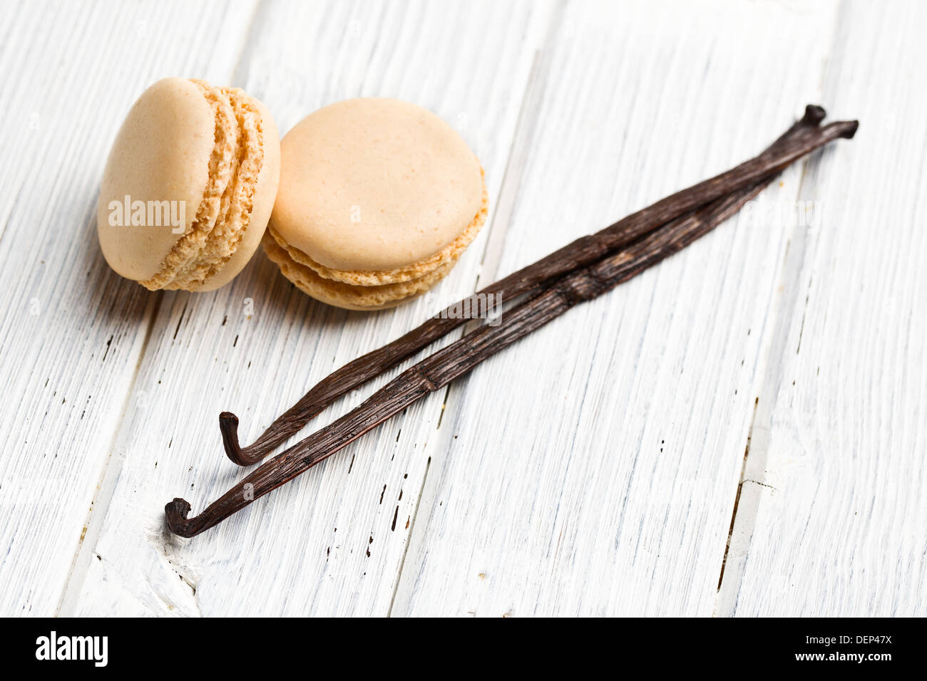 vanilla macaroons with vanilla pod on kitchen table Stock Photo