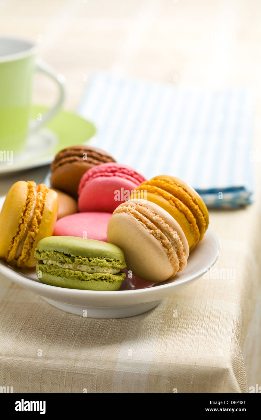 colorful macaroons in bowl on kitchen table Stock Photo