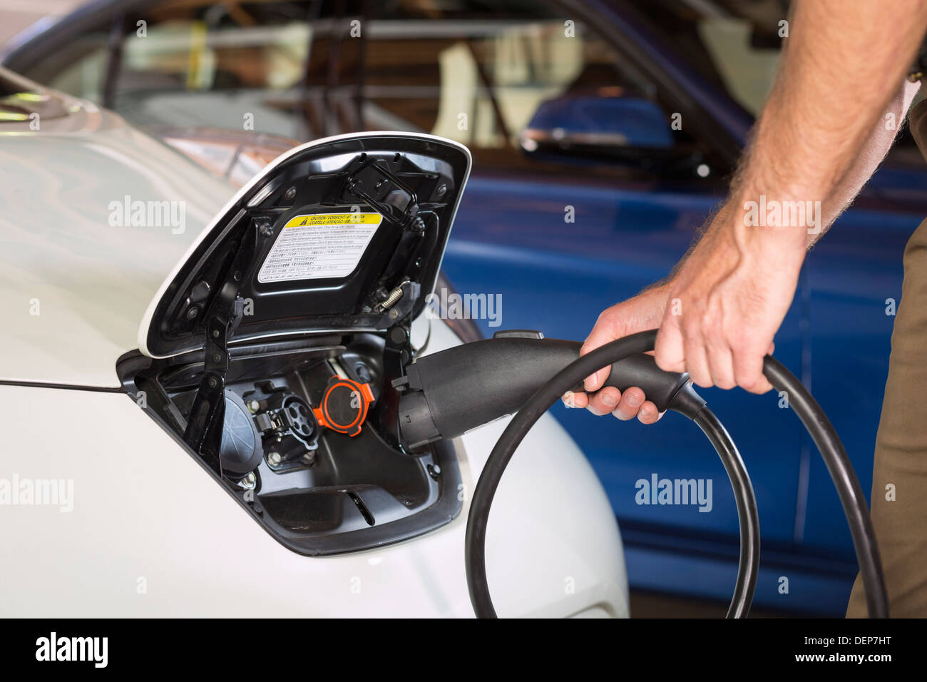 Close up of Caucasian man recharging electric car Stock Photo