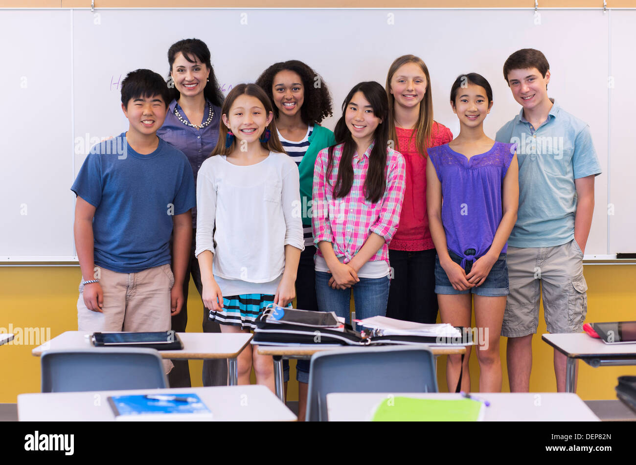 Teacher and students smiling in classroom Stock Photo