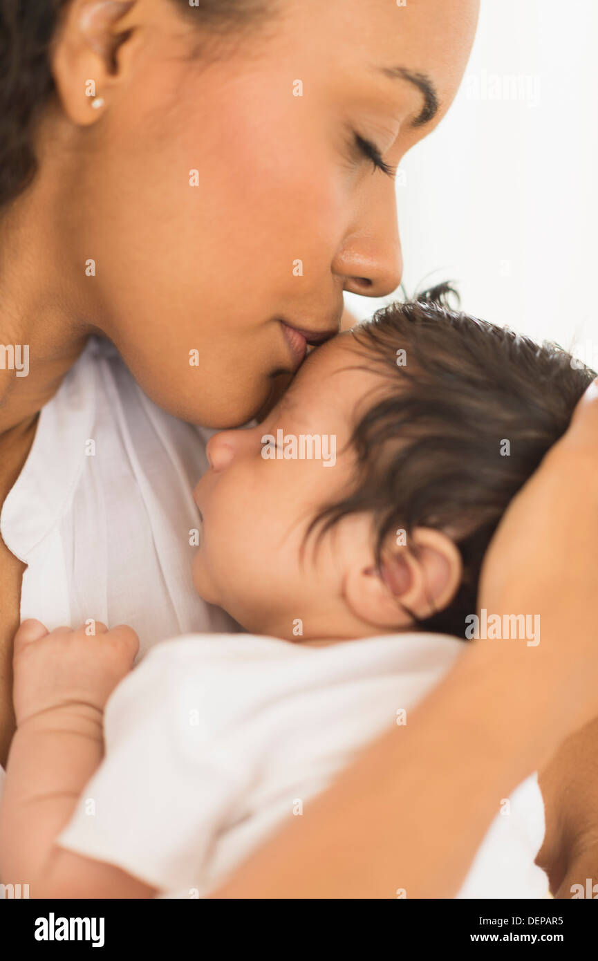Hispanic mother kissing infant son Stock Photo