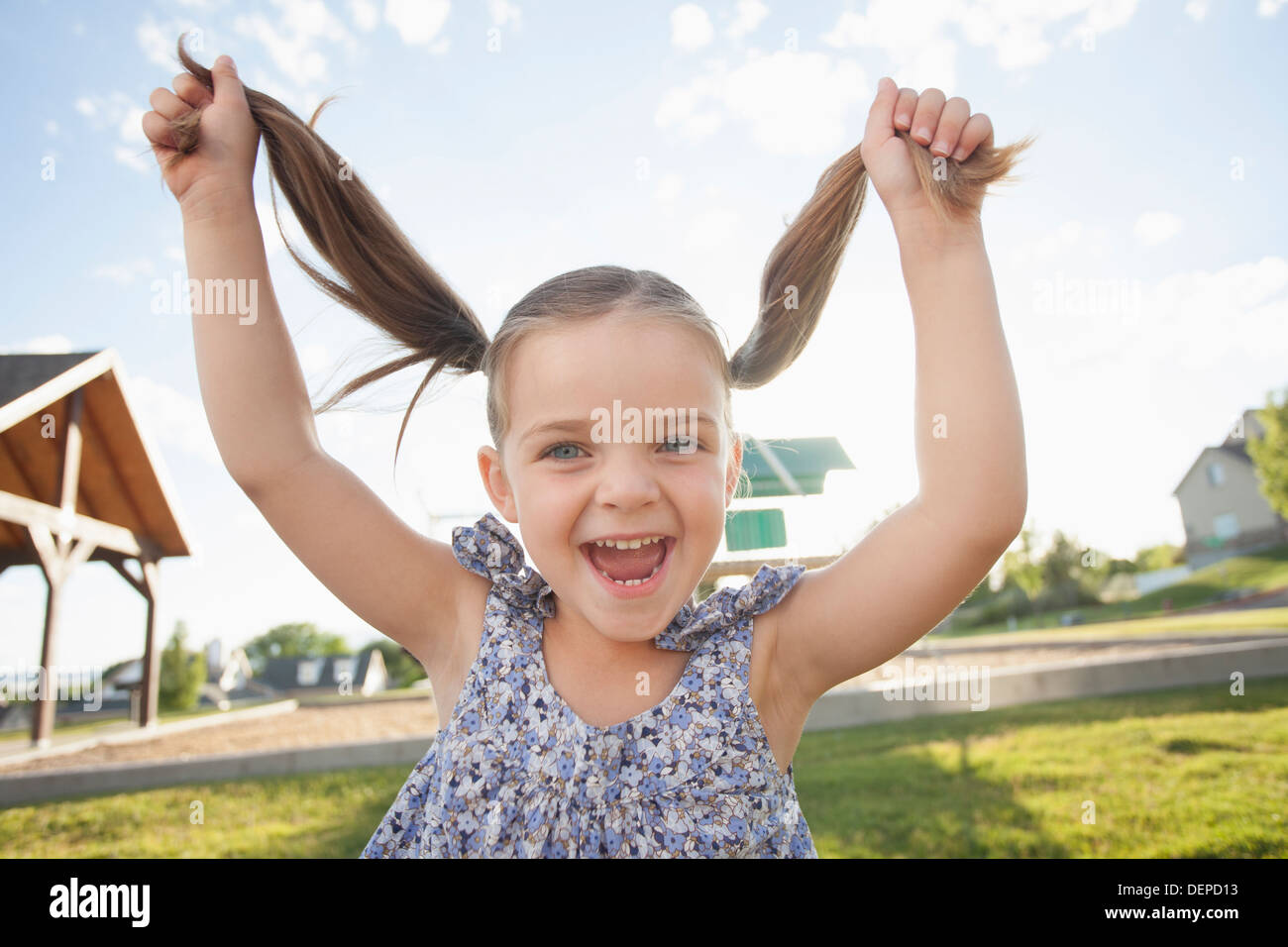 Caucasian girl playing with pigtails outdoors Stock Photo