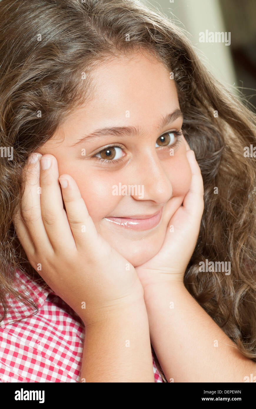 Happy little girl head in hands Stock Photo Alamy