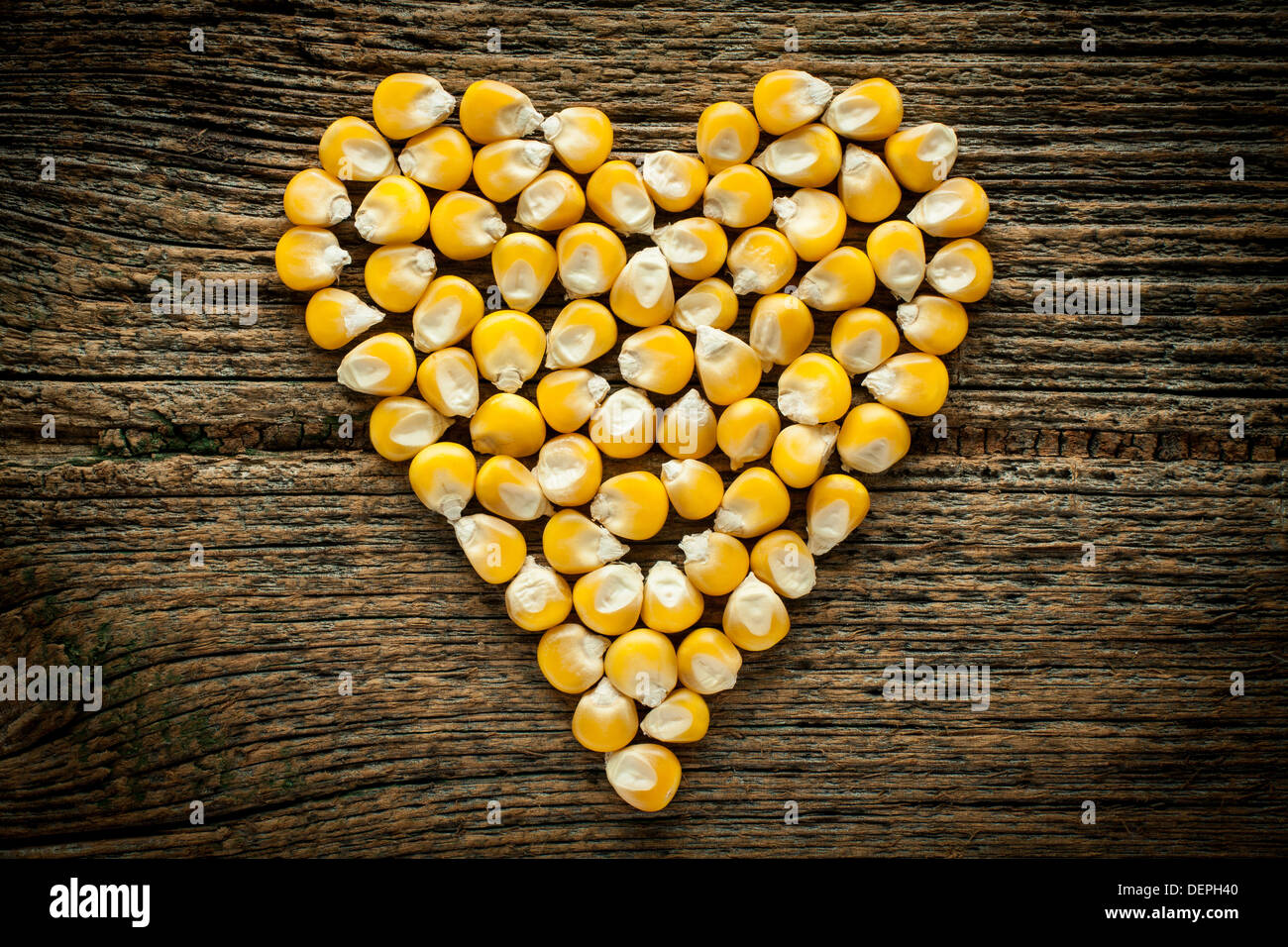 Corn grain on old wooden board Stock Photo