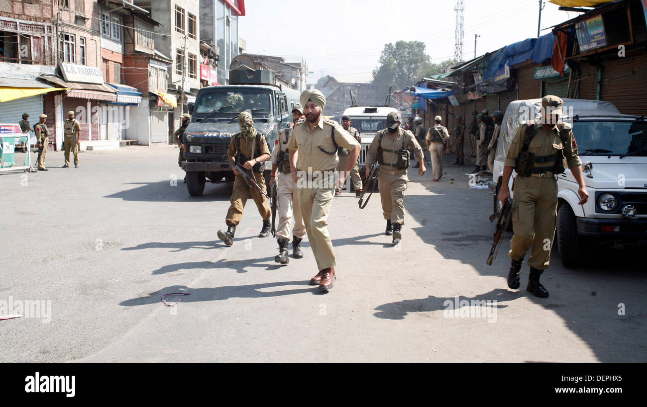 Srinagar, Indian Administered Kashmir. 23rd Sep, 2013. Indian policemen rush towards the site of  a suspected militant attack in Srinagar, the summer capital of Indian-administered Kashmir. A Central Industrial Security Froce(CISF) personnel was killed and another injured when militants shot at them in a busy market in Srinagar.  Sofi Suhail/ Alamy Live News Stock Photo