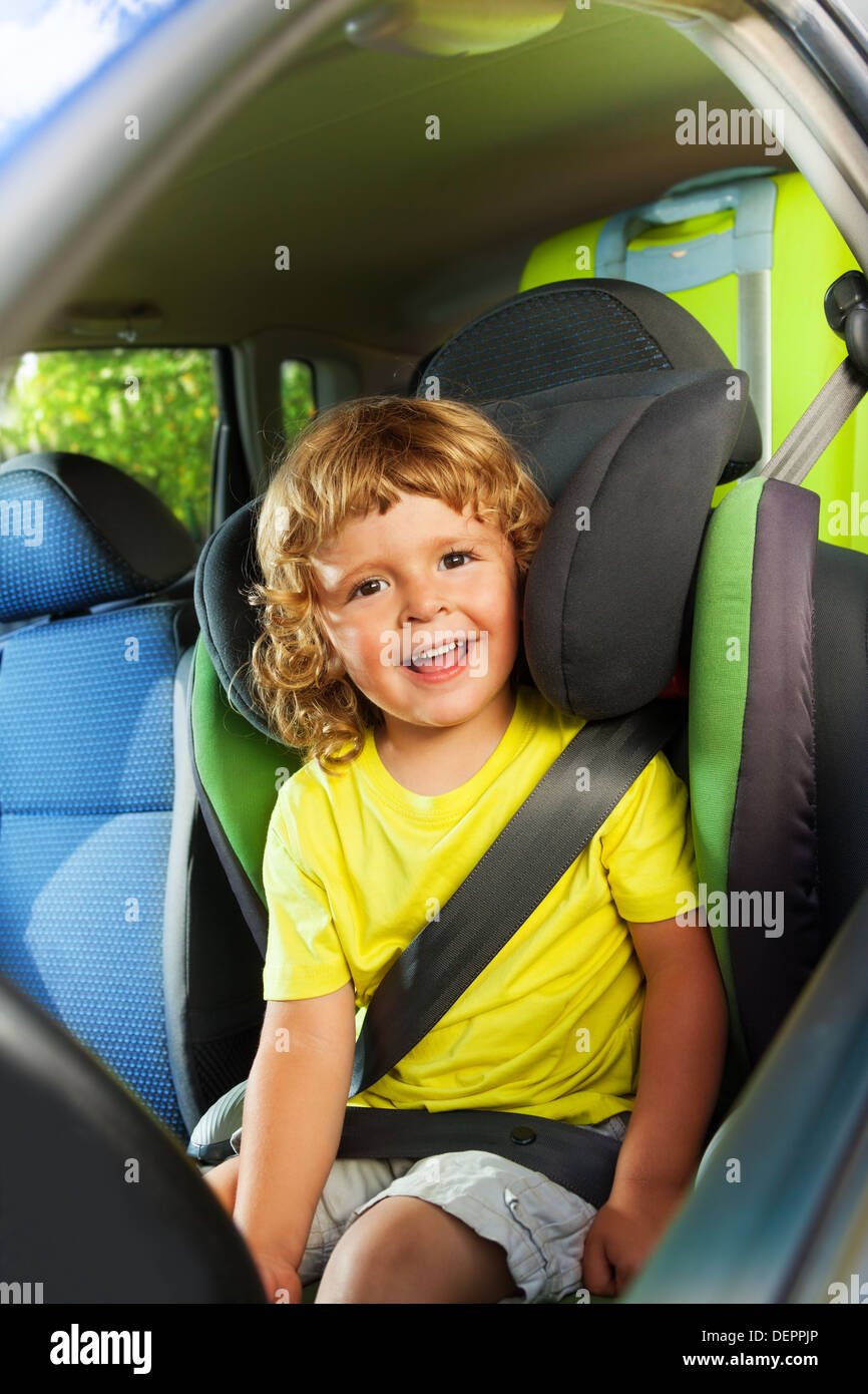 Little boy sitting on the child seat, happy and laughing on the back of