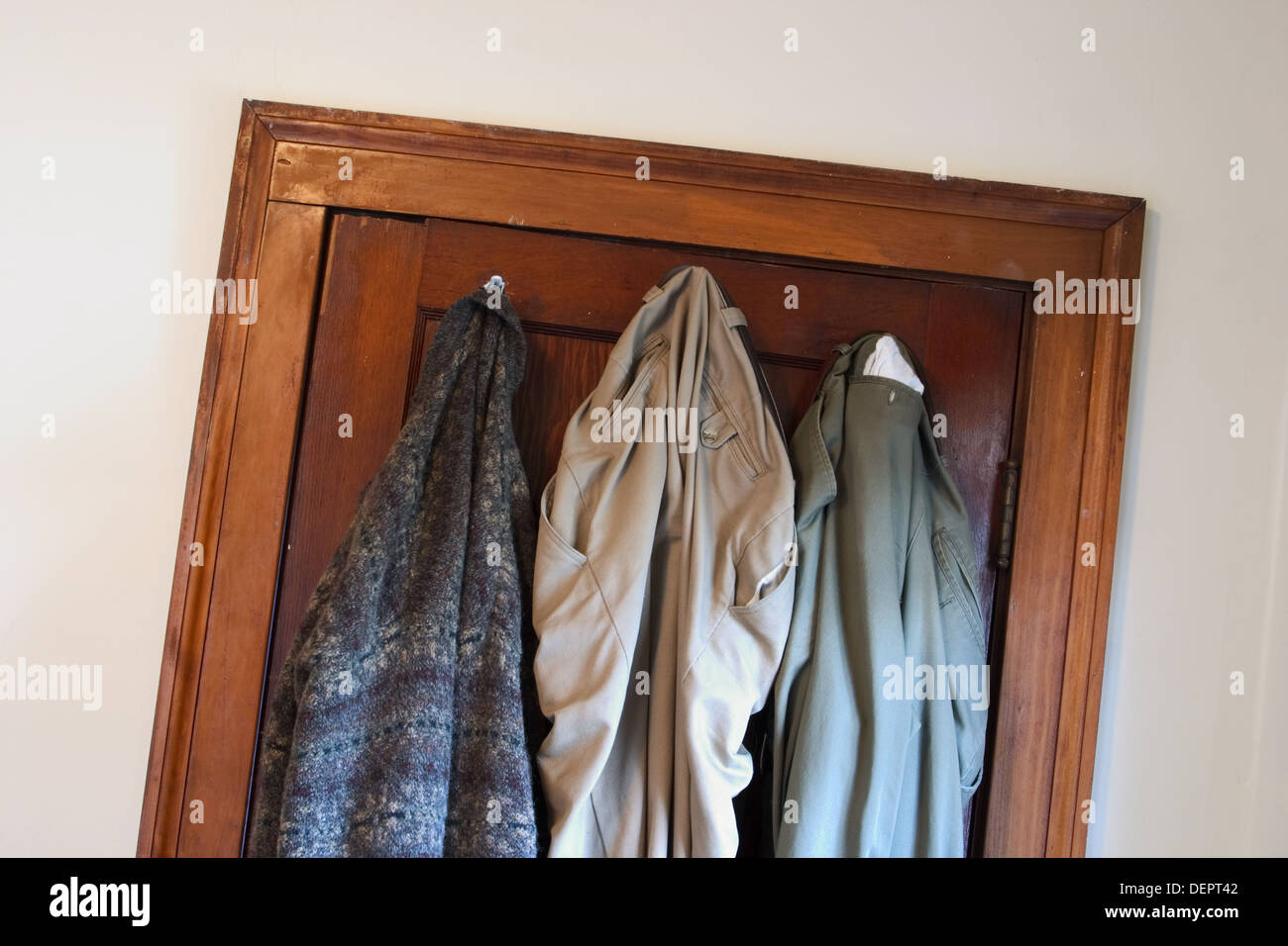 Man´s pants and sweater hanging on hooks on the back of his