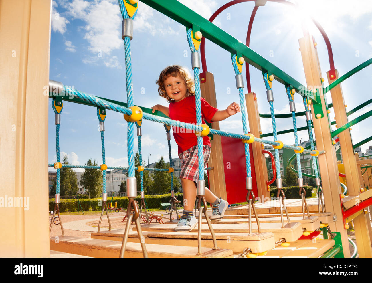 Happy running over the suspension bridge little three years old child ...