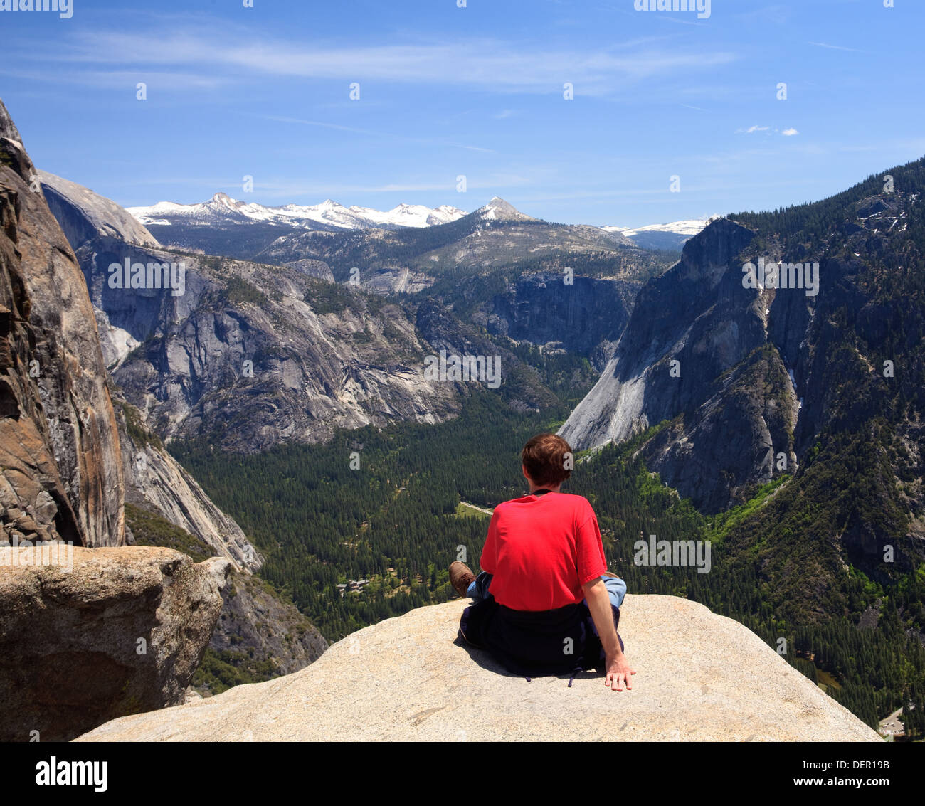 Hiker looking at the view from Yosemite Falls with Sierra Nevada mountains in Yosemite National Park, California, USA Stock Photo