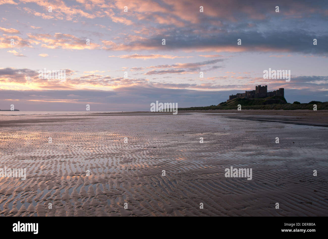 Bamburgh Castle and the beach at dawn in Bamburgh, Northumberland, UK Stock Photo