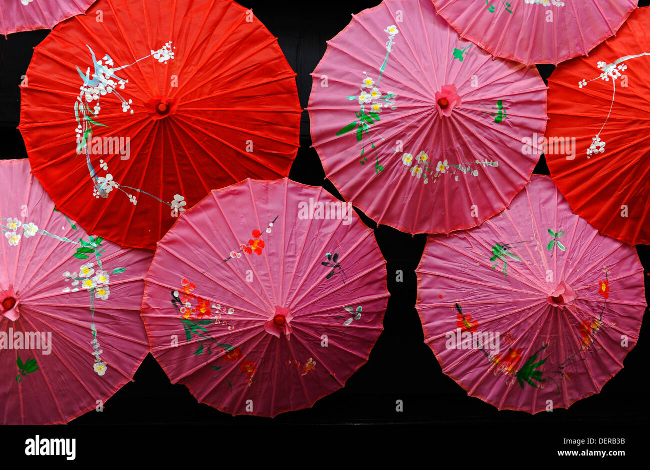 Red and pink Chinese style umbrellas with flower decorations hanging from  the ceiling of a shop Stock Photo - Alamy