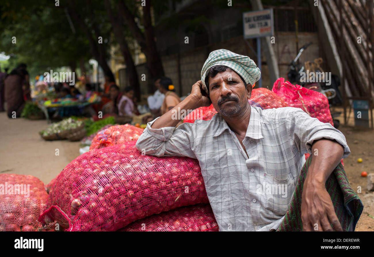 Indian man selling red onions at an Indian village market. Andhra Pradesh, India Stock Photo