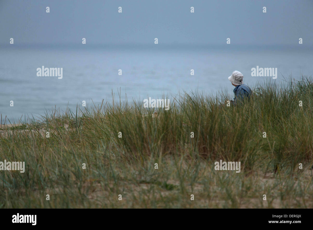 A man sit and contemplates by the sea Stock Photo