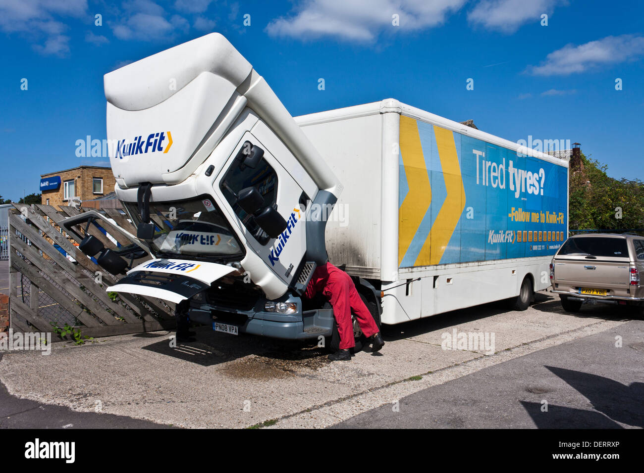 Mechanic repairs Kwik Fit HGV truck with the cab tilted forward. Reading, Berkshire, England, GB, UK Stock Photo