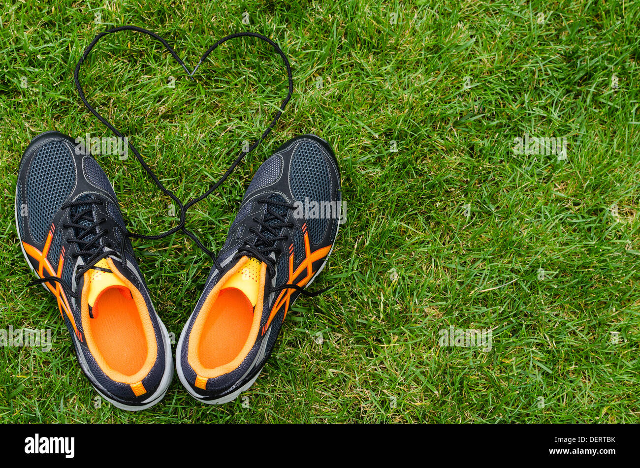 Black sneakers for running on grass with heart with space on right Stock Photo