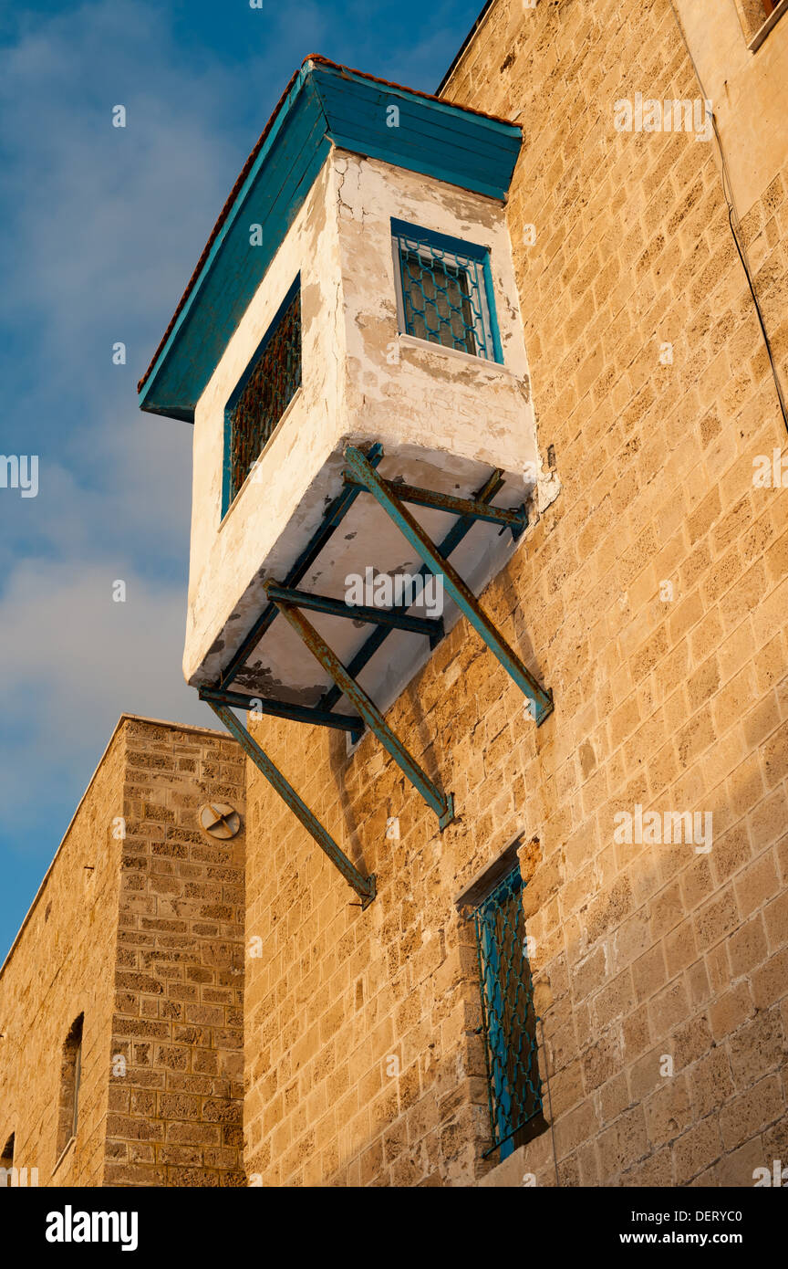An old house in an ally at Old Jaffa in the old port / marina area. A modern balcony is attached to the old building Stock Photo