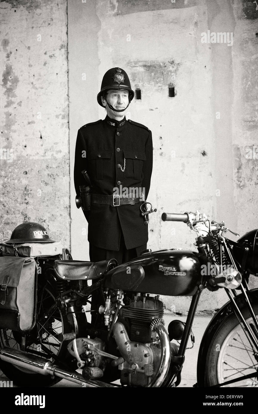 Man in 1940's 40s police uniform and Royal Enfield motor bike Stock Photo