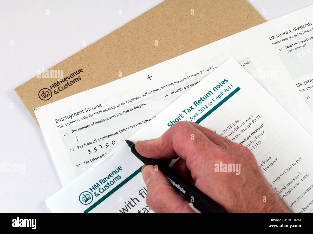 Person completing income tax return forms Stock Photo