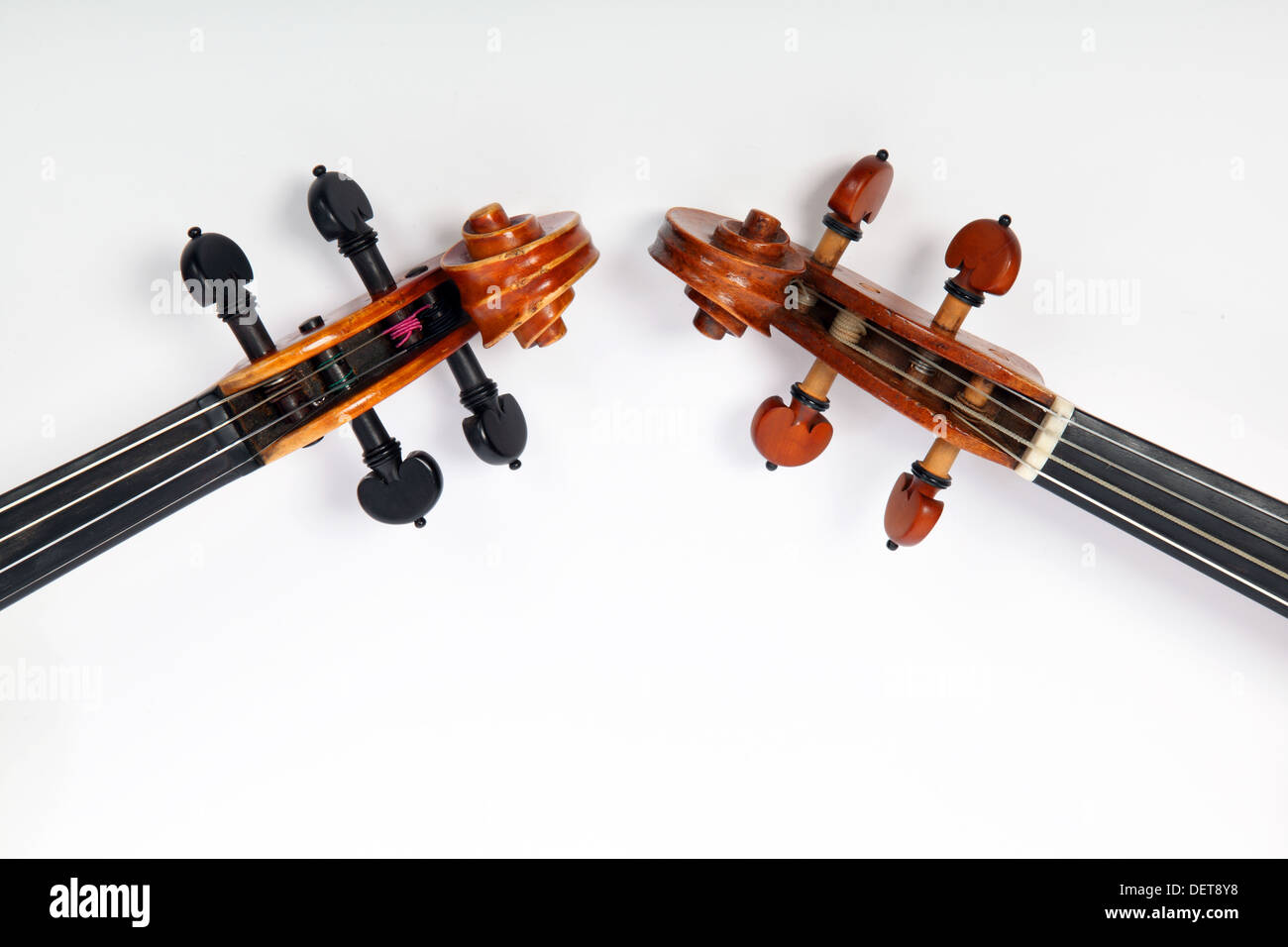 Two violin scrolls, one modern with steel strings, one baroque with gut