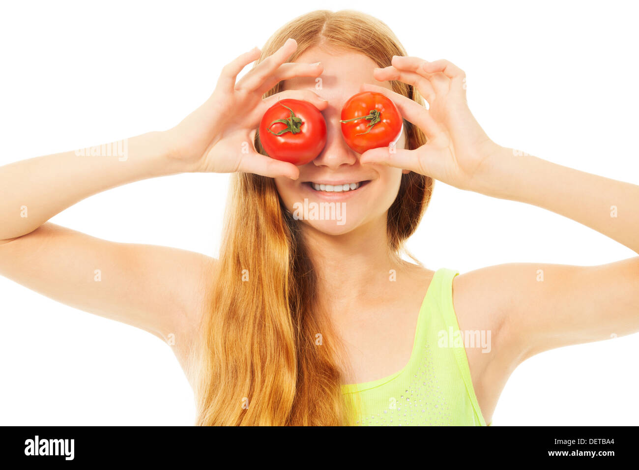 Funny blond girl holding two tomatoes near eyes and smiling Stock Photo ...