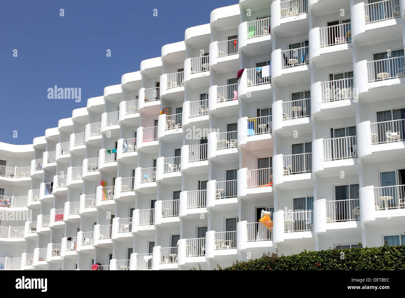 Generic white tourist hotel with towels hanging from balconies. Stock Photo