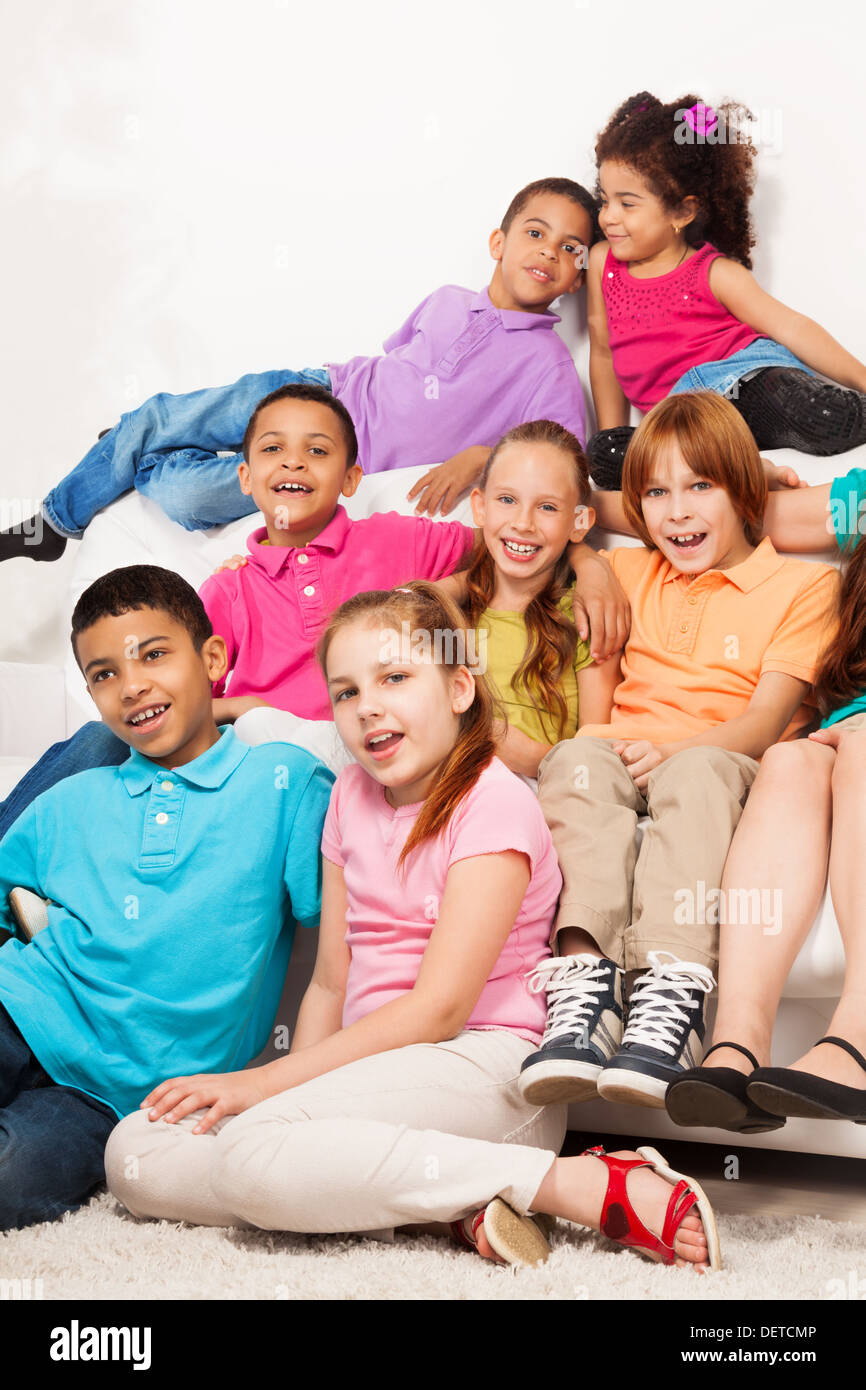 Group of friends, eight kids sitting on the coach together, boys and