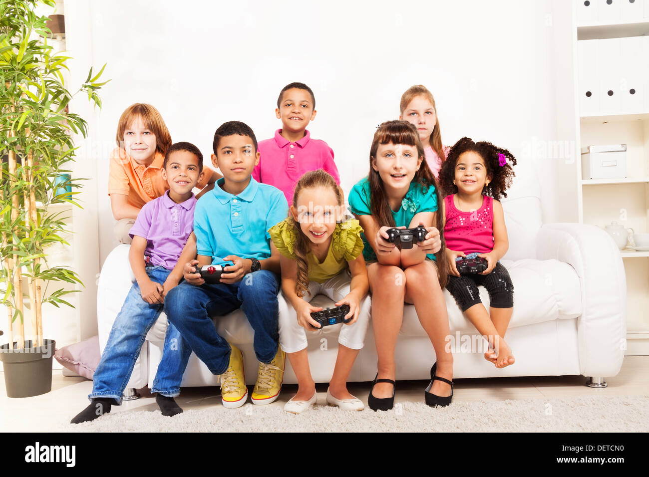 Group of diversity looking kids, boys and girls playing videogame