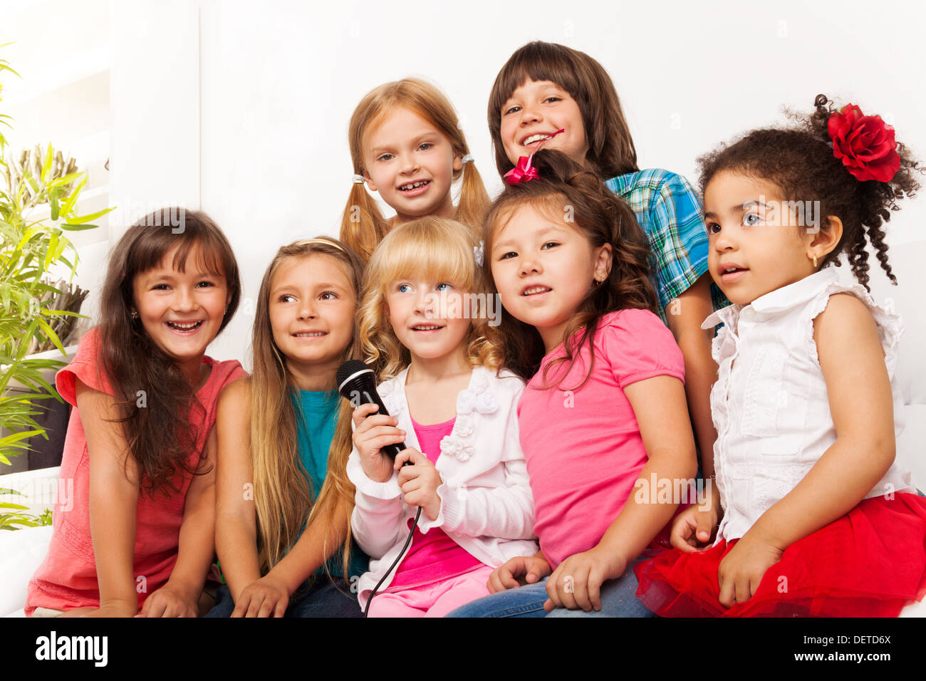 Large group of five happy little kids, boys and girls, singing together ...