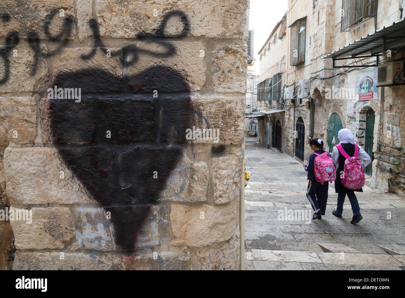 Heart grafitti and two Palestinian schoolgirls in the streets. Jerusalem Old City. Israel. Stock Photo