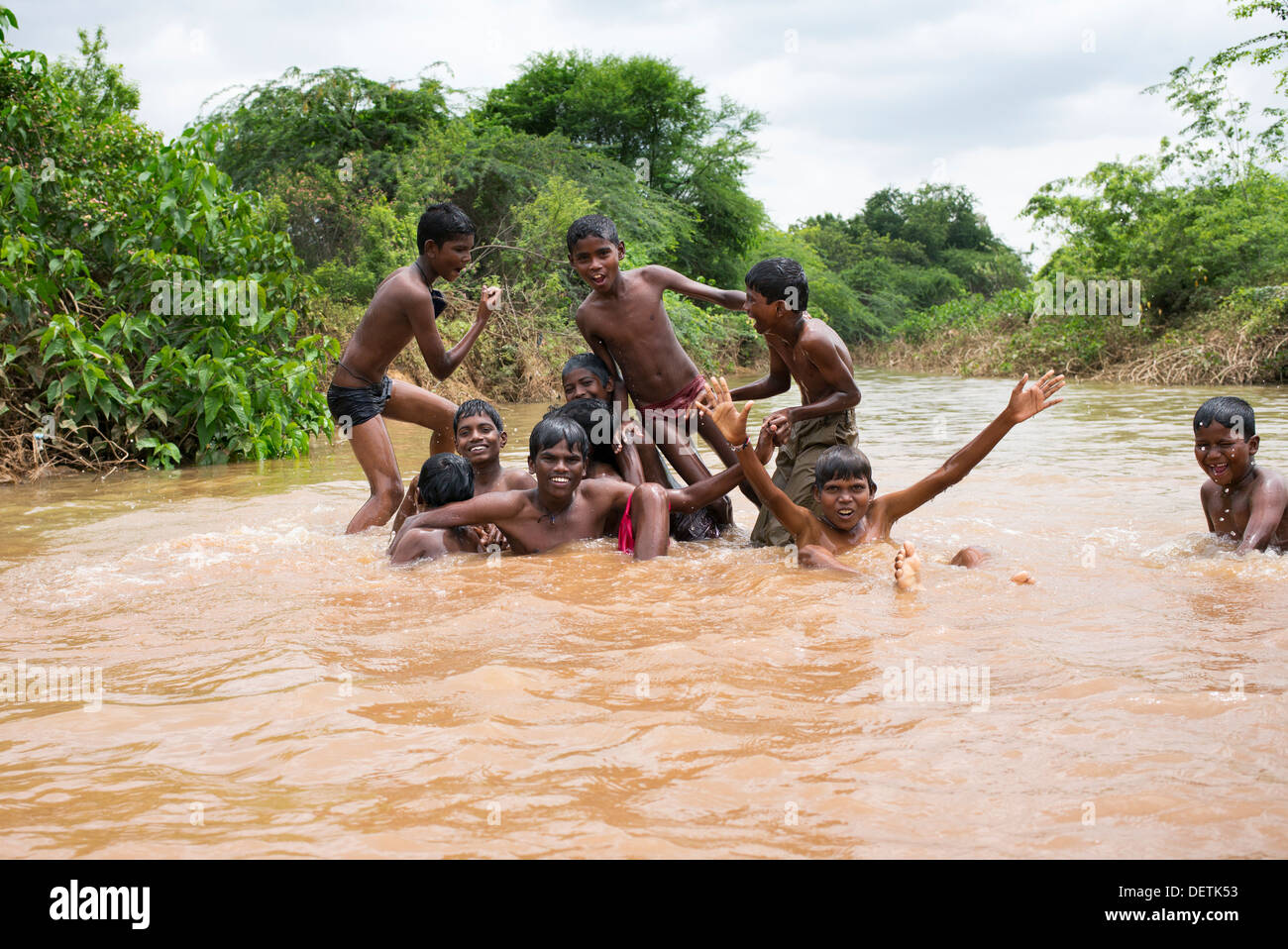 Rural Indian village boys playing and messing about in a flooded river. Andhra Pradesh, India Stock Photo