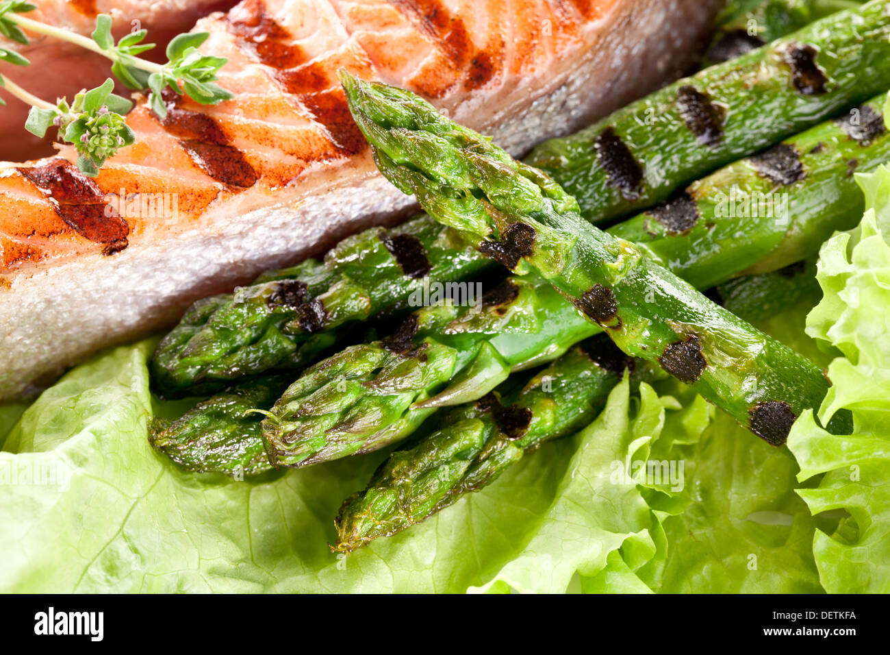 Grilled salmon and asparagus over lettuce leaves. Close up shot. Stock Photo