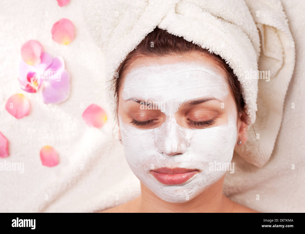 Young woman with clay facial mask in beauty salon. Stock Photo