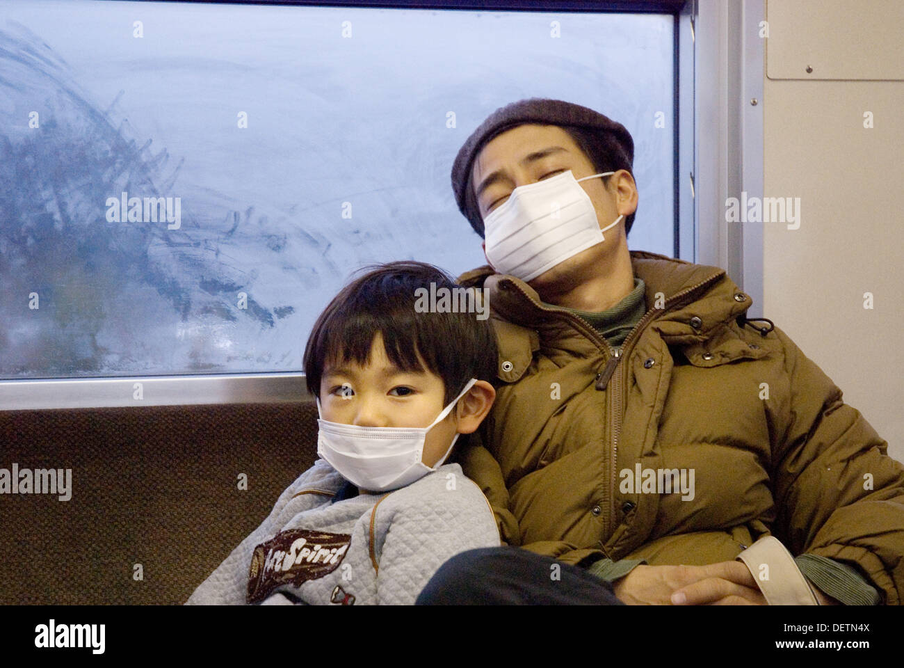 Father and son in train, wearing surgical masks. Japan Stock Photo Alamy